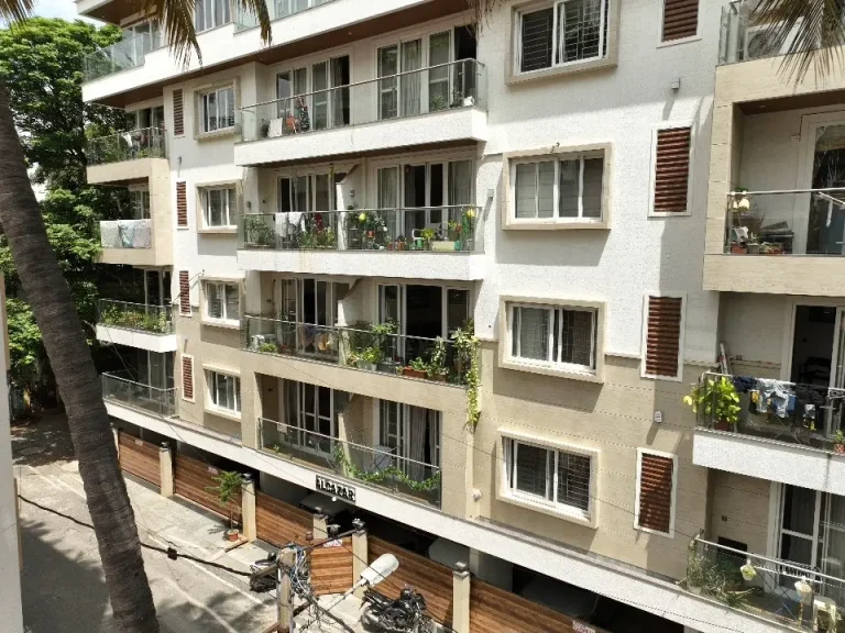 Modern apartment building exterior with balconies and greenery