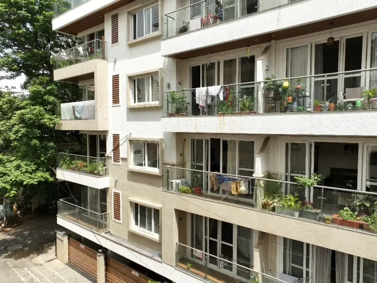 Modern apartment exterior with balconies and greenery