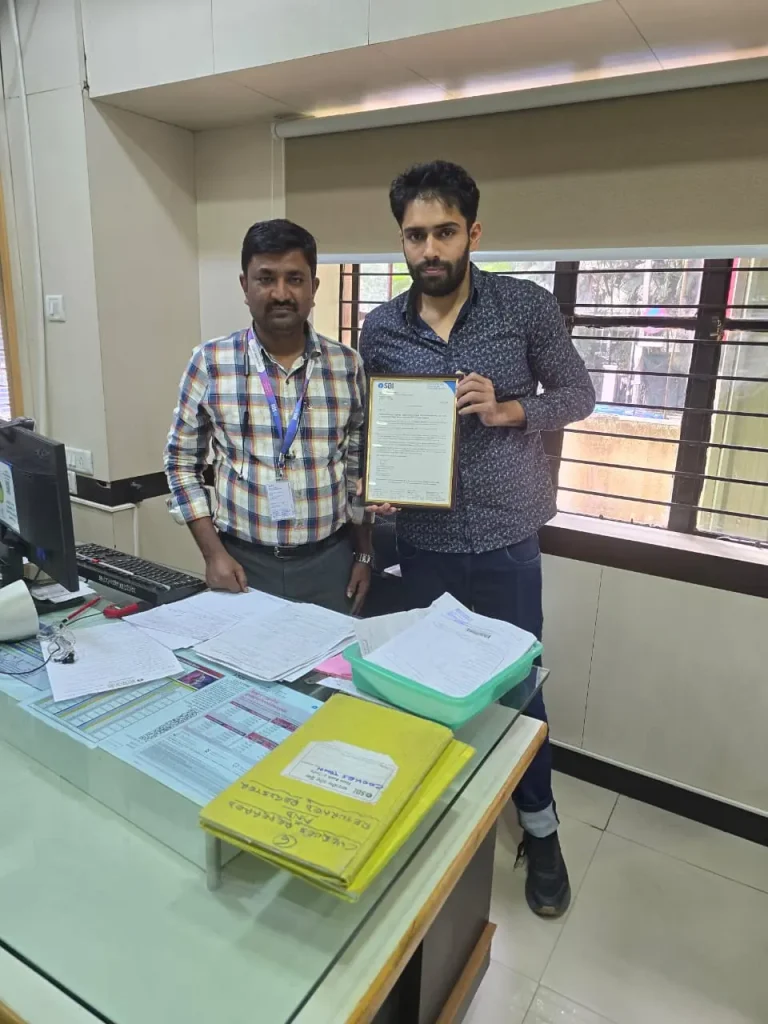Mohammed Zaid holding a certificate with a professional at an SBI office.